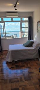 ein Schlafzimmer mit einem Bett und einem großen Fenster in der Unterkunft 13 andar, Studio, Centro, vista incrivel Guaíba in Porto Alegre