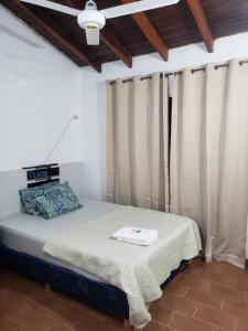 een bed in een kamer met gordijnen en een plafond bij Apartamento Vca Paraguay in Villarrica