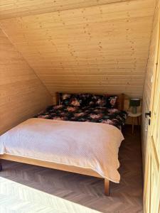 a bed in a room with a wooden ceiling at Noclegi Bieszczady, Domek na Bani 2 in Łukowe