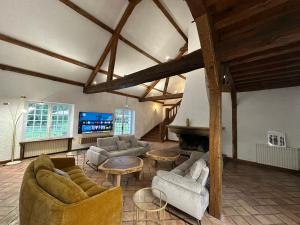 Una gran sala de estar con sofás y chimenea. en Domaine de Chevillons, en Chevillon-sur-Huillard