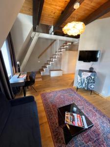 ein Wohnzimmer im Dachgeschoss mit einer Treppe und einem Teppich in der Unterkunft Apartmenthaus am Dom mit Parkplatz in Zwickau
