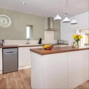 a kitchen with a counter with a bowl of fruit on it at Church House Barn Lake District & Solway Coast with Solway Firth views in Silloth +51 photos