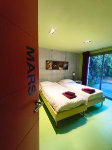 a bedroom with two beds and a door to a room at ღ Villa des Astres 850 m2 - Piscine, Sauna, Hammam, & Salle de Cinéma in La Noue +56 photos