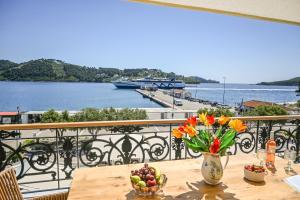 a table with a vase of flowers on a balcony at Nisaki House in Skiathos