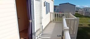 a door to a house with a white porch at The cosy getaway in Selsey