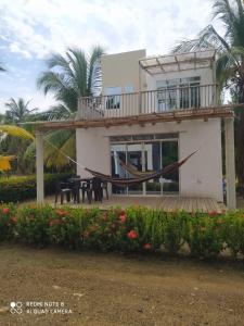 a house with a hammock in front of it at cabañas Brisas y Perla by AMAUNA in Moñitos