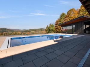 a swimming pool on a roof of a house at Casita Alta - Woodstock, VT - Main House & Pool House with Private Heated Pool and Mountain Views in Woodstock