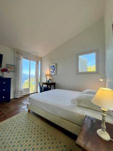 a bedroom with a large bed and a window at Villa Gardelina in Campomoro