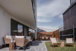 a patio with wicker chairs and tables on a building at Apartament Vidok in Nowy Targ
