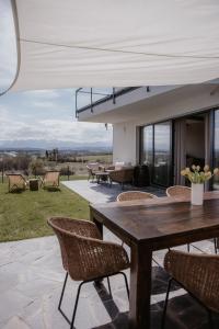 a patio with a wooden table and chairs at Apartament Vidok in Nowy Targ