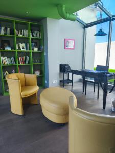 a library with a chair and a table and bookshelves at ღ Villa des Astres 850 m2 - Piscine, Sauna, Hammam, & Salle de Cinéma in La Noue