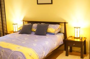 een slaapkamer met een bed met 2 nachtkastjes en 2 lampen bij Lindsays of Kangaroo Island in Penneshaw