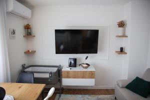 a living room with a flat screen tv on a wall at Roza Cozy Apartment in Vinkovci +3 photos