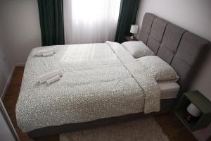 a bedroom with a large bed with two pillows at Roza Cozy Apartment in Vinkovci
