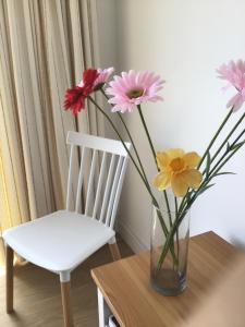 a vase of flowers sitting on a table next to a chair at Huerta Nueva 2º Izquierda in Santa Cruz de la Palma