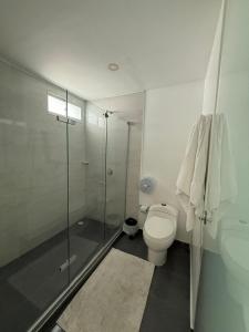 a bathroom with a toilet and a glass shower at Hotel Casa Nico in Barranquilla +12 photos