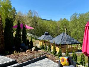 a wooden cabin with two roofs in a garden at Bieszczadzka Panorama in Ustrzyki Dolne
