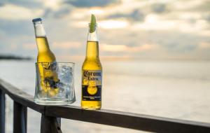 two bottles of beer sitting on a rail with a glass at Santa Maria Atins in Atins
