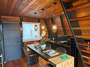 a kitchen with wooden ceilings and a table and chairs at Chez Chalet in Lavras Novas
