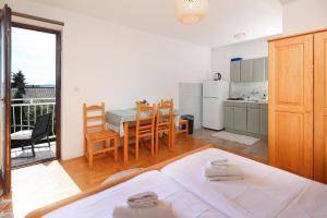 a room with a kitchen and a table with a bed at Apartments Kala in Jadranovo