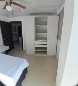 ein Schlafzimmer mit einem weißen Bett und einem Deckenventilator in der Unterkunft En el Centro de Matagalpa in Matagalpa
