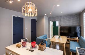 a living room with blue chairs and a television at Rental Whole House Sakaemachi in Furano +3 photos