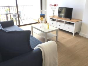a living room with a couch and a tv and a table at Huerta Nueva 2º Izquierda in Santa Cruz de la Palma