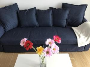a blue couch with a vase of flowers on a table at Huerta Nueva 2º Izquierda in Santa Cruz de la Palma