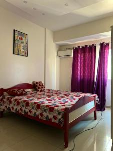 a bedroom with a bed with purple curtains at Mo Residence SD City in Dakar +46 photos
