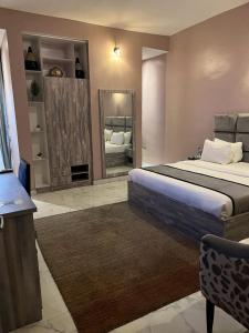 a bedroom with a large bed and a mirror at La VOD Hotel in Benin City