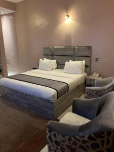 a bedroom with a bed and two chairs at La VOD Hotel in Benin City +24 photos