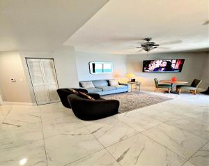 a living room with a couch and chairs and a tv at 14th Floor 2 BR Resort Condo Direct Oceanfront Wyndham Ocean Walk Resort Daytona Beach 1401 in Daytona Beach