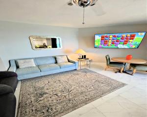 a living room with a blue couch and a table at 14th Floor 2 BR Resort Condo Direct Oceanfront Wyndham Ocean Walk Resort Daytona Beach 1401 in Daytona Beach +57 photos