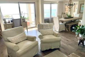 a living room with two chairs and a table at Regency Towers Unit 803E in Pensacola Beach