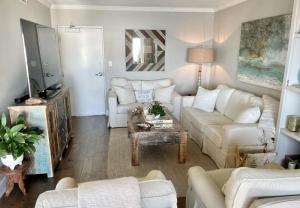 a living room with a white couch and a table at Regency Towers Unit 803E in Pensacola Beach +32 photos