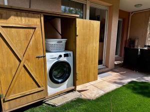 een wasmachine en droger in een houten schuur bij CAP THALASSA - Beau 2P - Piscine - Parking - AC in Roquebrune-Cap-Martin