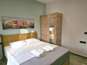 a bedroom with a bed with two towels on it at Zenozy luxury apartments in Corfu Town