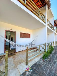 a house with a hammock in the courtyard at Pousada Curva dos Ventos-Próximo à praia com café da manhã em Icaraí de Amontada in Icaraí