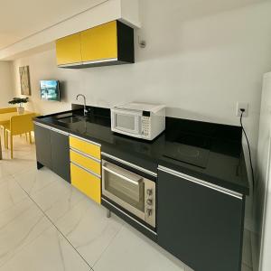 a kitchen with a microwave and a stove top oven at 202 Landscape - torre Gold B in Fortaleza