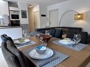 een eettafel met borden en wijnglazen bij CAP THALASSA - Beau 2P - Piscine - Parking - AC in Roquebrune-Cap-Martin