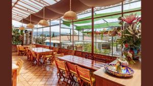 a restaurant with wooden tables and chairs and windows at HOTEL BOUTIQUE 14 LANCEROS in Paipa