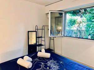 een kamer met een bed, handdoeken en een raam bij CAP THALASSA - Beau 2P - Piscine - Parking - AC in Roquebrune-Cap-Martin +8 foto's