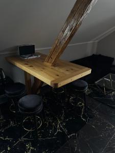 un tavolo di legno con sgabelli e un computer portatile sopra di NEW GUEST HOUSE 13 a Maribor