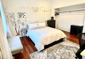 a bedroom with a bed and a tree mural on the wall at Your Vacation Home in the Hills of Studio City in Studio City
