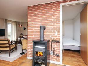 a living room with a brick wall and a fireplace at Serene Seaside Retreat at Hegedal-By Traum in Glesborg