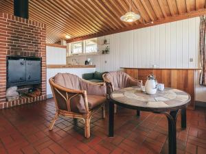 a living room with a table and chairs and a fireplace at 6 person holiday home in Gilleleje in Gilleleje