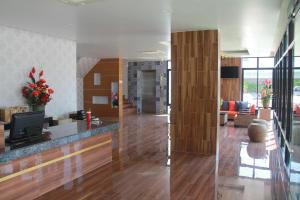 two images of a living room and a kitchen with wood at Tawan Anda Garden Hotel in Surat Thani