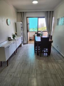 a kitchen and dining room with a table and chairs at Apartamento Peruíbe in Peruíbe