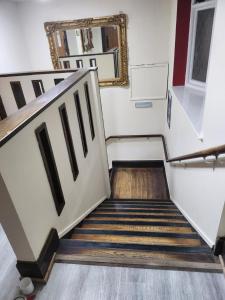 a set of stairs with a mirror on the wall at The Queensberry Hotel in Dumfries