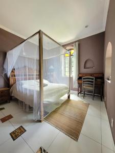 a bedroom with a canopy bed and a desk at soulrebel rio - Vegan Retreat & SPA in Rio de Janeiro
